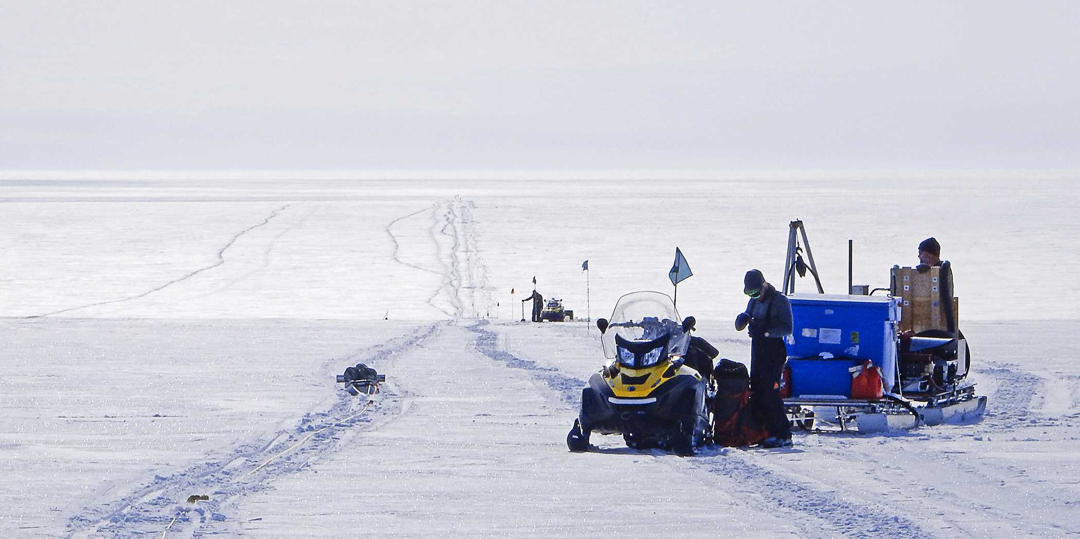 This image shows Antarctica and researchers setting up posts at regular intervals.